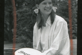 Sally Ride '72 wearing pigtails and holding a tennis racquet